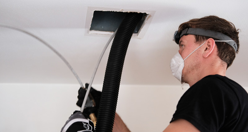 A man cleaning an air duct